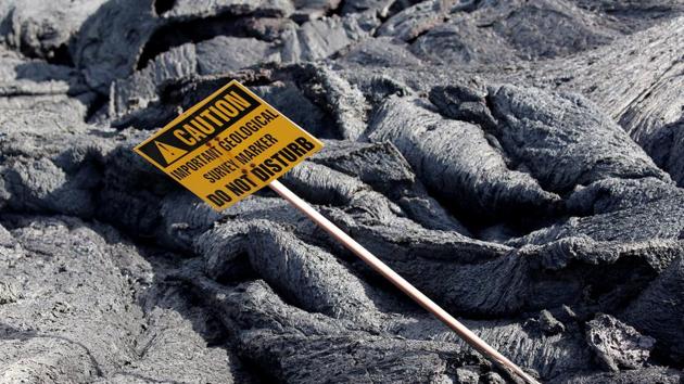 A 'Caution' sign stands in a lava flow on the outskirts of Pahoa. Halekamahina Hill, and its couple of dozen farmlets are now surrounded on three sides by lava, including one bright, churning, molten flow. The eruptions seemed to influence the weather. Fierce hot winds blew between the houses, rattling ripped sheet metal and torn up greenhouses. (Terray Sylvester / REUTERS) A 'Caution' sign stands in a lava flow on the outskirts of Pahoa. Halekamahina Hill, and its couple of dozen farmlets are now surrounded on three sides by lava, including one bright, churning, molten flow. The eruptions seemed to influence the weather. Fierce hot winds blew between the houses, rattling ripped sheet metal and torn up greenhouses. (Terray Sylvester / REUTERS)