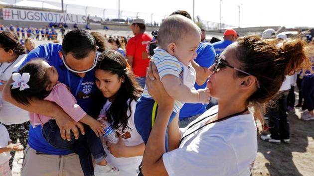 Marcelino Pizarro greets his daughter, Denisse, and for the first time granddaughter Aitana, as his daughter, Fatima Paola, holds her baby brother, Matias, during a greeting for family members from both sides of the border during the "Hugs not Walls" event on the border of Juarez, Mexico, and El Paso, Texas, U.S., May 12, 2018.(REUTERS File Photo)