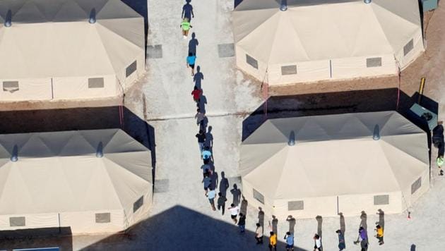 Immigrant children, many of whom have been separated from their parents under a new "zero tolerance" policy by the Trump administration, walk in single file between tents in their compound next to the Mexican border in Tornillo, Texas.(Reuters Photo)
