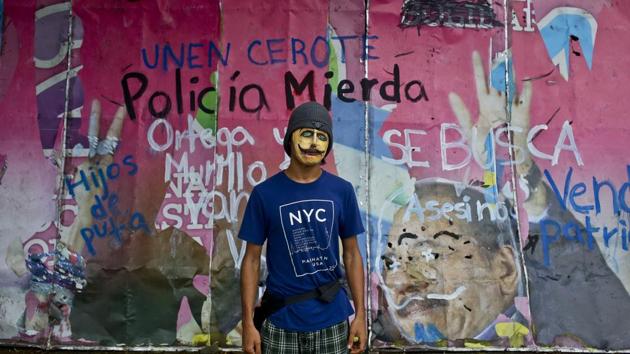 A student stands wearing a mask, in front of a defaced billboard of Nicaragua’s President Daniel Ortega and his wife and Vice President Rosario Murillo, outside the Agrarian University in Managua. During two months of anti-government protests, symbols of Ortega’s administration and even the earlier Sandinista revolution he helped lead have been defaced, destroyed or sometimes appropriated by demonstrators. (Esteban Felix / AP)