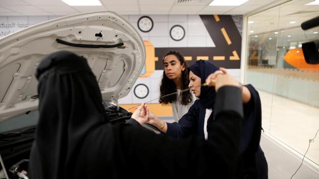 Maria al-Faraj (C) and Amira Abdelgader check oil levels in the engine with their driving instructor (R) during a lesson. “We need the car to do our daily activities. We are working, we are mothers, we have a lot of social networking, we need to go out - so we need transport,” Abdelgader said. “It will change my life.” (Ahmed Jadallah / REUTERS) 