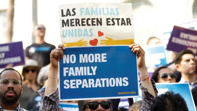 People hold signs to protest against US President Donald Trump's executive order to detain children crossing the southern US border and separating families outside of City Hall in Los Angeles, California.(Reuters Photo)