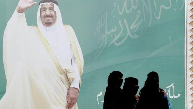 Women walk past a poster of Saudi Arabia's King Salman bin Abdulaziz Al Saud on the outskirts of Riyadh, Saudi Arabia.(Reuters File Photo)