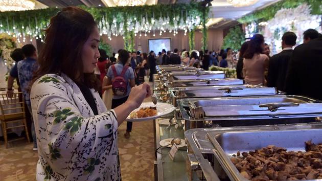 A guest puts food on her plate during a wedding at a hotel in Jakarta. Even as it struggles with poverty and malnutrition, the Southeast Asian nation bins more edible food per person than any other country except Saudi Arabia, according to an Economist Intelligence Unit survey last year. (Adek Berry / AFP)