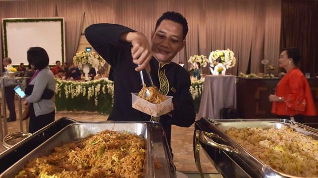 A waiter packs uneaten food for distribution after a wedding in Jakarta. Indonesia’s 260 million citizens each throw out an average of almost 300 kilograms of food annually, ahead of the United States in third spot, the survey said. The country’s food waste problem can be partly chalked up to local hospitality, which calls for ample helpings at all celebrations. (Adek Berry / AFP)