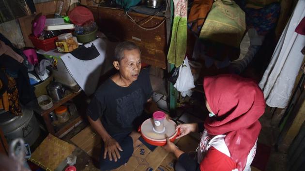 For 60-year-old scavenger Efendi, getting a meal from one couple’s lavish nuptials across town was a welcome surprise. “I didn’t expect this -- suddenly I’m getting free food,” he said. (Adek Berry / AFP)