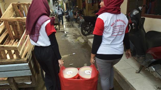 Volunteers of the programme “A Blessing to Share” carry containers with uneaten food as they distribute leftovers in a slum area in Jakarta. In the slums of Jakarta, Indonesia’s poor are getting a taste of how the other half live thanks to this new programme that aims to take a bite out of the country’s mammoth food-waste problem. (Adek Berry / AFP)