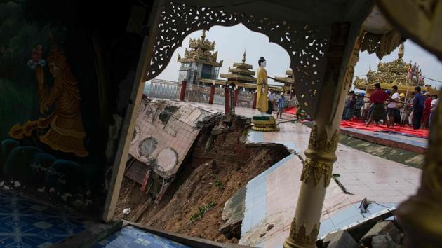 Rains triggered a landslide that damaged the hilltop Kyeik Than Lan pagoda, whose golden stupa towers over state capital Mawlamyine. Workers were seen helping to relocate Buddha statues and novice monks helped clean up debris at the religious site after a wedge of hillside slipped away. (Ye Aung Thu / AFP)