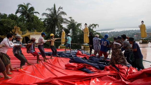 Rescue workers and Buddhist monks clear debris after a landslide in Mawlamyine. The pagoda was also made famous by English poet Rudyard Kipling’s poem “Mandalay” which opens with the line: “By the old Moulmein Pagoda, Looking lazy at the sea”. (Ye Aung Thu / AFP)