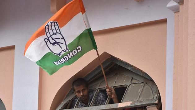 A Congress supporter waves party flag in Bengaluru.(Arijit Sen/HT Photo)
