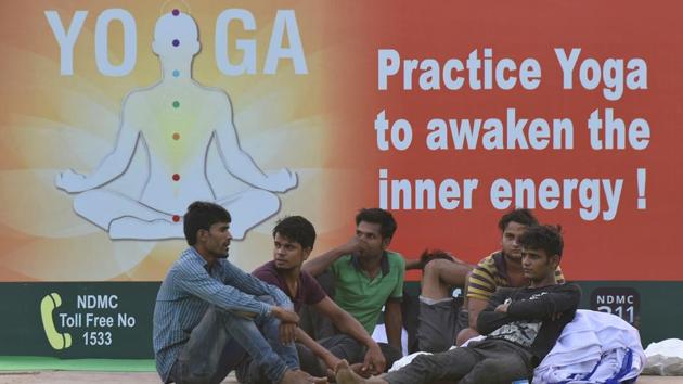 Labourers seen sitting at the lawns of Rajpath ahead of International Yoga Day, in New Delhi on June 20.(Vipin Kumar/HT PHOTO) Labourers seen sitting at the lawns of Rajpath ahead of International Yoga Day, in New Delhi on June 20.(Vipin Kumar/HT PHOTO)