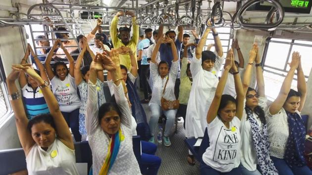 Yoga teachers from different schools practice yoga with the commuters inside a local train on western railway line in Mumbai. (Pratik Chorge / HT Photo) Yoga teachers from different schools practice yoga with the commuters inside a local train on western railway line in Mumbai. (Pratik Chorge / HT Photo)