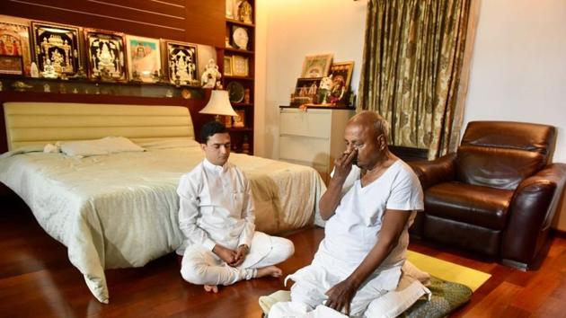 Former Prime Minister of India and Janta Dal (secular) national president H D Devegowda performs yoga while a teacher assists him at his residence in Bengaluru. (Arijit Sen / HT Photo) Former Prime Minister of India and Janta Dal (secular) national president H D Devegowda performs yoga while a teacher assists him at his residence in Bengaluru. (Arijit Sen / HT Photo)