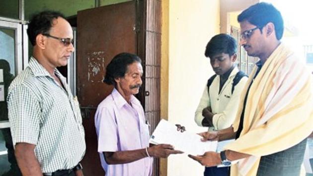 Jhuka Bauri handing over land documents to Soumendranath Mandal, headmaster of school. (HT Photo) Jhuka Bauri handing over land documents to Soumendranath Mandal, headmaster of school. (HT Photo)
