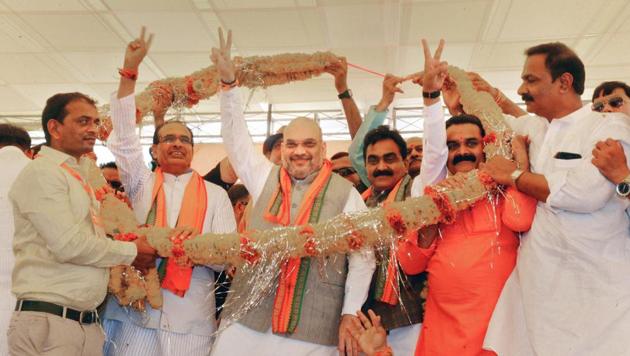 BJP President Amit Shah, flanked by Madhya Pradesh Chief Minister Shivraj Singh Chauhan (L) and BJP state chief Rakesh Singh being garlanded by party workers in Jabalpur on June 12, 2018. (PTI File Photo) BJP President Amit Shah, flanked by Madhya Pradesh Chief Minister Shivraj Singh Chauhan (L) and BJP state chief Rakesh Singh being garlanded by party workers in Jabalpur on June 12, 2018. (PTI File Photo)