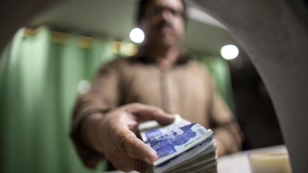 An employee shows a bundle of Pakistani one thousand rupee banknotes at a cash counter of the office of Pakistan Currency Exchange Pvt in Karachi, Pakistan. (Asim Hafeez/Bloomberg) An employee shows a bundle of Pakistani one thousand rupee banknotes at a cash counter of the office of Pakistan Currency Exchange Pvt in Karachi, Pakistan. (Asim Hafeez/Bloomberg)