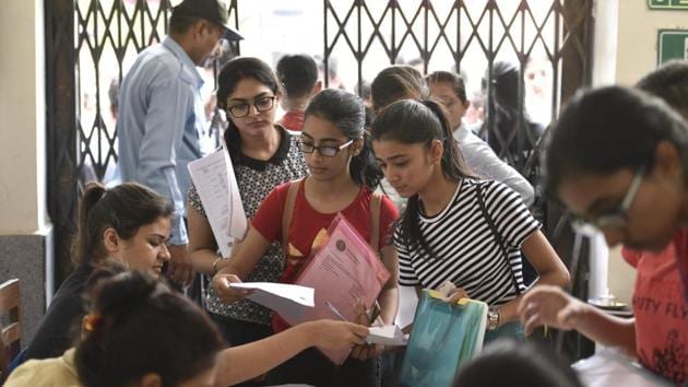 Delhi university aspirants fill admission forms at Daulat Ram College on Wednesday.(Sanchit Khanna/HT PHOTO)