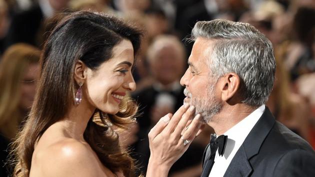 Actor/director George Clooney, right, is greeted by his wife Amal as he arrives in the ballroom at the 46th AFI Life Achievement Award gala honoring him at the Dolby Theatre.(Chris Pizzello/Invision/AP)