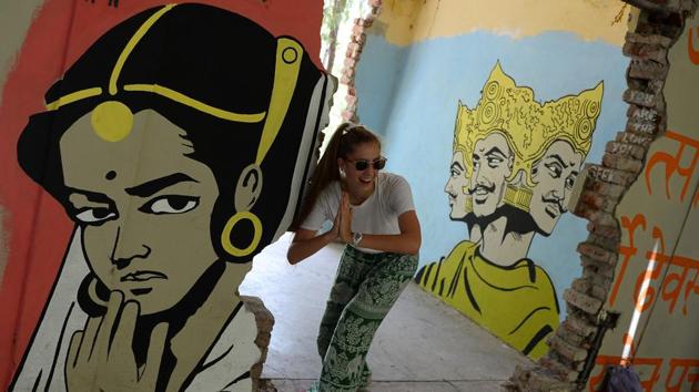 A tourist poses next to murals at the now-derelict ashram attended by The Beatles. The rest of the day is free for meditation, reading, chatting and local trips before more yoga at 6 pm, supper and early bed. The facility is not completely cut off from the modern world however, offering Wi-Fi. “I still look at Facebook as I like to share pictures from my trip,” Rueda said. (Sajjad Hussain / AFP)