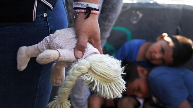 A Mexican woman holds a doll next to children at the Paso Del Norte Port of Entry, in the US-Mexico border in Chihuahua state, Mexico on June 20, 2018. US President Donald Trump said he would sign an executive order to keep migrant families together at the border with Mexico, amid an escalating uproar over the separation of children from their parents. (AFP Photo) A Mexican woman holds a doll next to children at the Paso Del Norte Port of Entry, in the US-Mexico border in Chihuahua state, Mexico on June 20, 2018. US President Donald Trump said he would sign an executive order to keep migrant families together at the border with Mexico, amid an escalating uproar over the separation of children from their parents. (AFP Photo)