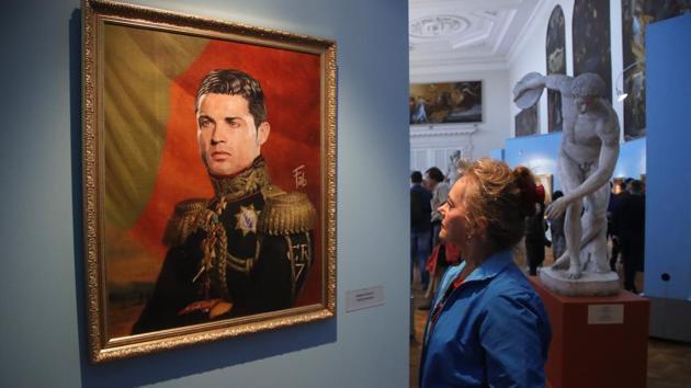 A visitor examines a portrait of Portugal's Cristiano Ronaldo at the Museum of Academy of Arts in St.Petersburg, Russia. (AP)