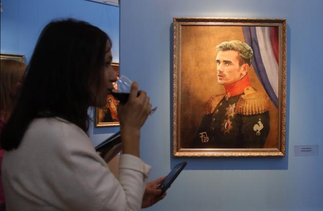 A visitor walks past portrait of France football team star Antoine Griezmann at the Museum of Academy of Arts. (AP)