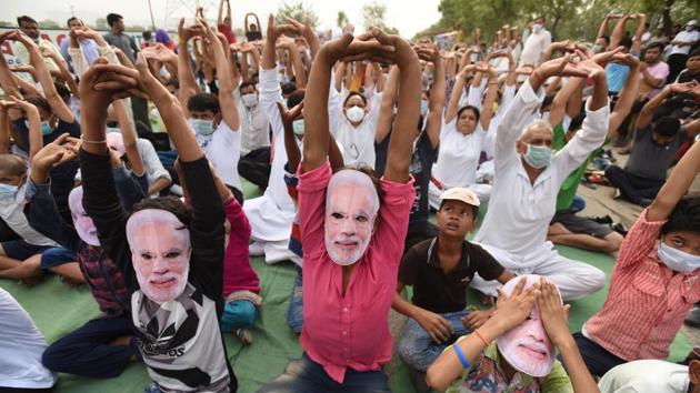 Residents perform yoga while wearing Modi’s face mask and pollution mask near the dumping ground at Noida’s sector-123. (Virendra Singh Gosain / HT Photo) Residents perform yoga while wearing Modi’s face mask and pollution mask near the dumping ground at Noida’s sector-123. (Virendra Singh Gosain / HT Photo)