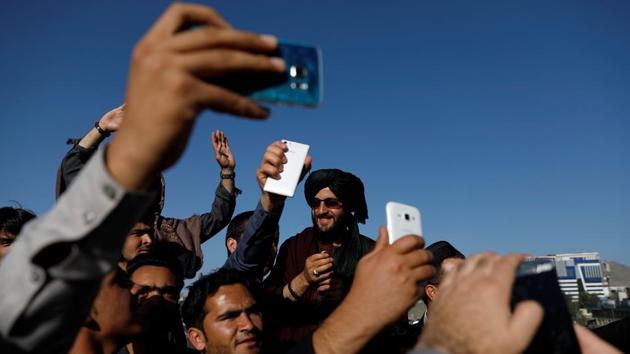 Afghans take picture with a Taliban during a ceasefire in Kabul, Afghanistan. (Mohammad Ismail / REUTERS)