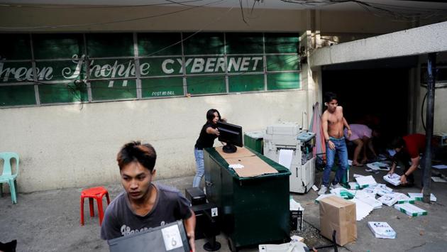Shop workers bring out office equipment outside a shopping centre being gutted by a fire. Hours after a fire is put out, residents salvage whatever they can reuse and rebuild their homes - just as flammable as they were before. (Erik De Castro / REUTERS) Shop workers bring out office equipment outside a shopping centre being gutted by a fire. Hours after a fire is put out, residents salvage whatever they can reuse and rebuild their homes - just as flammable as they were before. (Erik De Castro / REUTERS)
