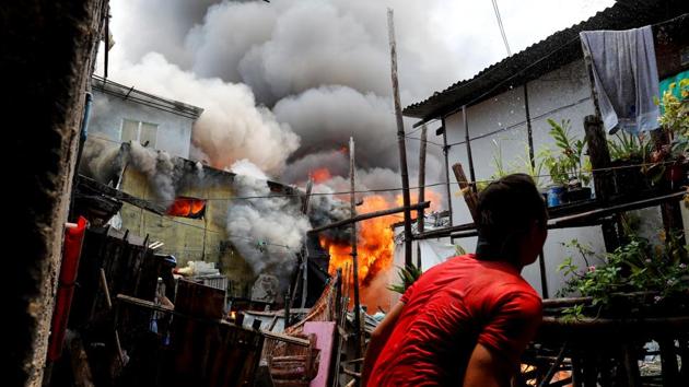 One scorching afternoon this month, inhabitants of a slum in the Philippine capital of Manila frantically hurled buckets of water to try to save their homes from a raging fire. Six hours later, their efforts proved to no avail. (Erik De Castro / REUTERS) One scorching afternoon this month, inhabitants of a slum in the Philippine capital of Manila frantically hurled buckets of water to try to save their homes from a raging fire. Six hours later, their efforts proved to no avail. (Erik De Castro / REUTERS)