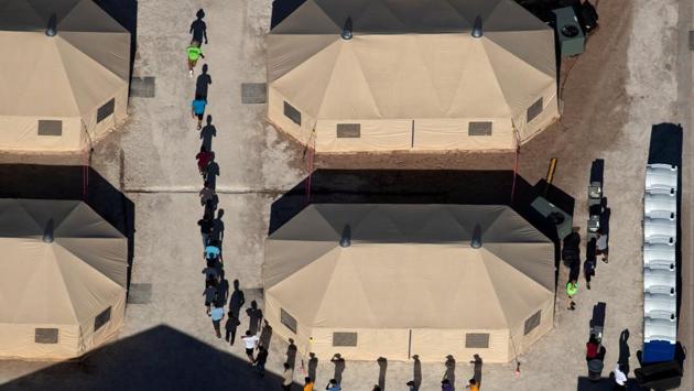 Immigrant children are led by staff in single file between tents at a detention facility next to the Mexican border in Tornillo, Texas, US. (Mike Blake / REUTERS)