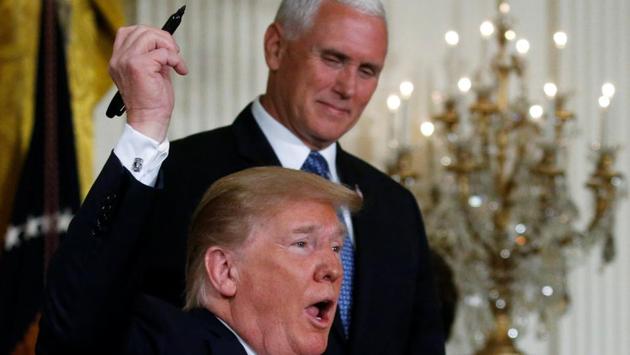 US President Donald Trump raises his pen after signing a national space policy directive during a meeting of the National Space Council in the East Room of the White House in Washington, US. (Leah Millis / REUTERS)