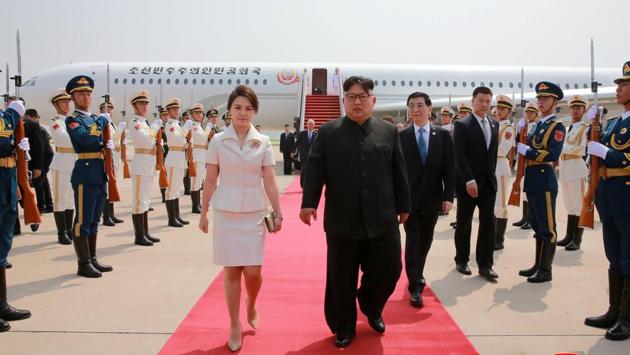 North Korean leader Kim Jong Un and his wife Ri Sol Ju walk from their aircraft upon arriving in Beijing, China. (KCNA via REUTERS)