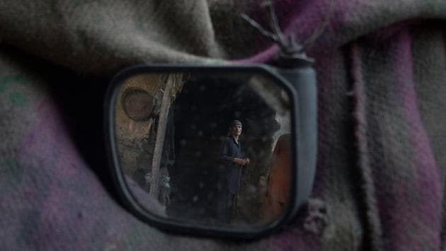 An Afghan day labourer works in a coal yard at the market in Mazar-i-Sharif. (Farshad Usayn / AFP)
