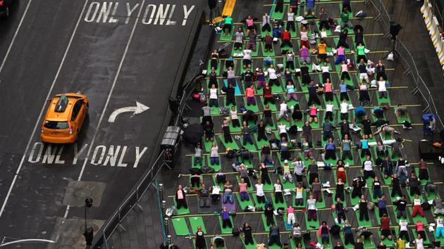 Thousands of people participate in “Mind Over Madness Yoga”, an annual all-day outdoor yoga event during the summer solstice in Times Square in New York. (Timothy A. Clary / AFP)