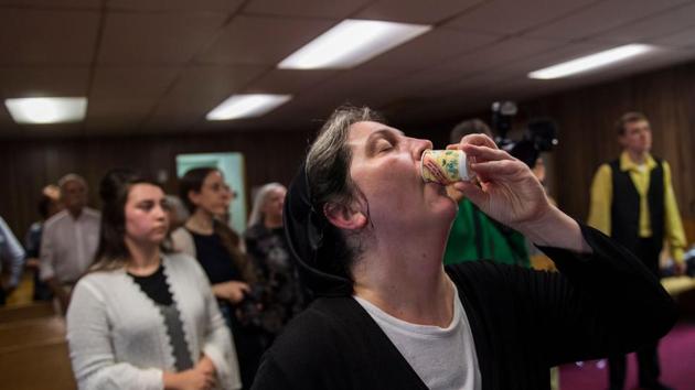 Robin Brandon drinks strychnine, a poison, as a test of faith during a service. Traditionally kept within the family, many members of the faith are related or closely connected. A few outsiders trickle in and some have become followers as well, but overall it feels like an extended family. (Andrew Caballero-Reynolds / AFP) Robin Brandon drinks strychnine, a poison, as a test of faith during a service. Traditionally kept within the family, many members of the faith are related or closely connected. A few outsiders trickle in and some have become followers as well, but overall it feels like an extended family. (Andrew Caballero-Reynolds / AFP)