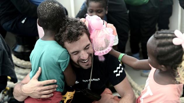 A crew member hugs a migrant child aboard the Aquarius rescue ship before disembarking in the port of Valencia, Spain. (Kenny Karpov / SOS Mediterranee / Handout via REUTERS)