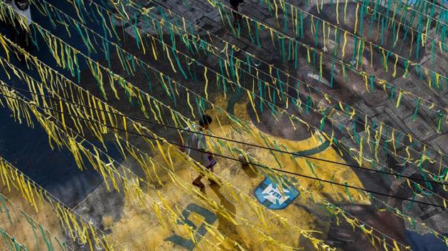 A boy plays football on a street painted with the image of Brazil footballer Gabriel Jesus in the neighbourhood where he grew up in Sao Paulo.(AFP)