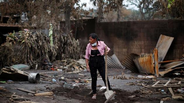 Eufemia Garcia Ixpata, a 48-year-old fruit vendor who lost dozens of family members during the eruption of the Fuego volcano, rests holding a shovel while searching for her family in San Miguel Los Lotes in Escuintla, Guatemala. (Carlos Jasso / REUTERS)