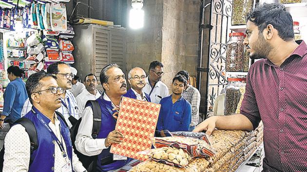 BMC inspectors speak to a shopkeeper in Mumbai on Saturday.(Kunal Patil/HT Photo)