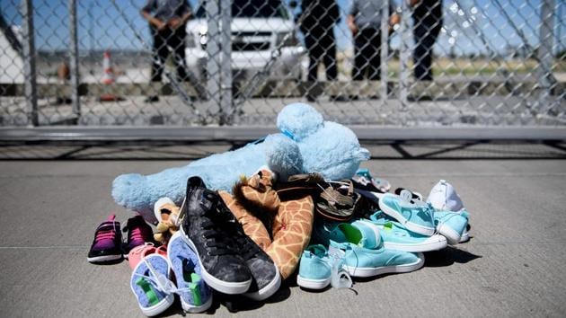 A file photo shows security personal standing before shoes and toys left at the Tornillo Port of Entry in Tornillo, Texas on June 21 where minors crossing the border without proper papers have been housed after being separated from adults(AFP File Photo)