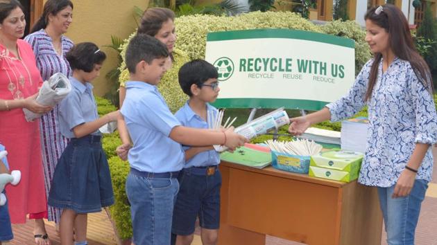 Students of The Gurukul School, Panchkula, exchanging scrap papers for stationery made from recycled paper with Anju Gupta, founder of Anadee.(HT Photo)