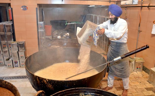 Karah parshad is made with almost equal quantities of whole wheat flour, desi ghee and sugar. It takes an hour to cook a steamy lot of parshad.(Sameer Sehgal/HT)