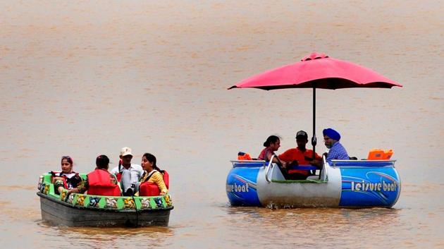 Tourists opt for a boat with an umbrella to ward off the scorching sun at Sukhna Lake, Chandigarh, on Sunday. (Ravi Kumar/HT) Tourists opt for a boat with an umbrella to ward off the scorching sun at Sukhna Lake, Chandigarh, on Sunday. (Ravi Kumar/HT)
