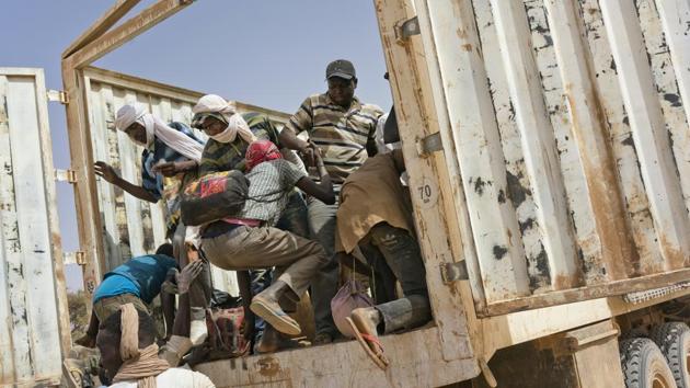 Migrants climb into a truck heading north into Algeria at the Assamaka border post. The majority head towards Niger, where the lucky ones limp across a desolate 15kms no man’s land to Assamaka, less a town than a collection of unsteady buildings sinking into drifts of sand. Others, disoriented and dehydrated, wander for days before a UN rescue squad can find them. (Jerome Delay / AP)
