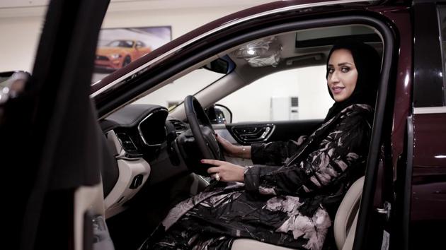 A car saleswoman poses for a photograph in Riyadh, Saudi Arabia. The lifting of the ban on women driving marks a milestone for women in the kingdom who have had to rely on drivers, male relatives, taxis and ride-hailing services to get to work, go shopping and simply move around(AP)