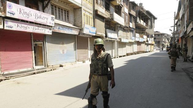 A paramilitary soldier stands guard in a closed market during a strike at Maisuma in Srinagar on Monday.(Waseem Andrabi/ Hindustan Times)