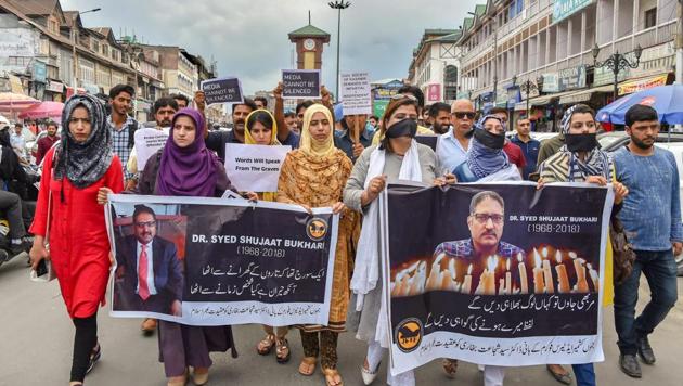 Journalists hold placards during a silent protest march against the killing of Rising Kashmir newspaper editor-in-chief Shujaat Bukhari, in Srinagar on June 26, 2018.(PTI Photo)