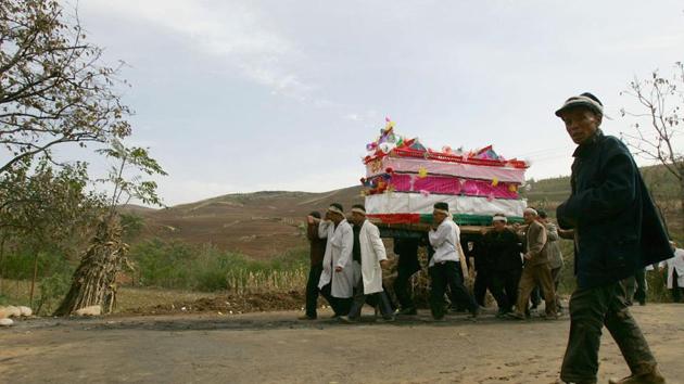 Family members carry the coffin of the dead during the funeral of a senior citizen in Jiaodai Township on October 27, 2005 in Lantian County of Shaanxi Province, China.(Getty Images)