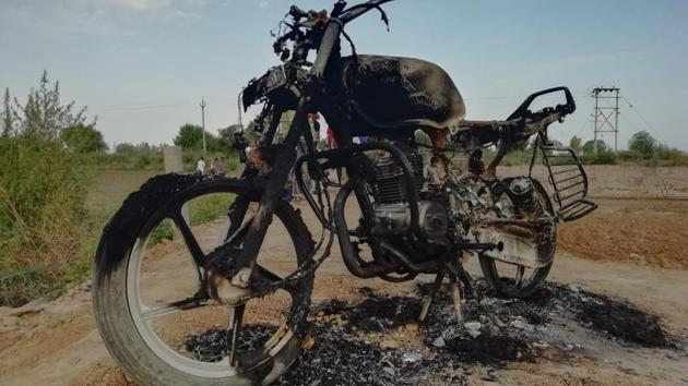 A motorcycle that was set ablaze during a clash between two villages at Hansi in Hisar district on Monday.(HT Photo)